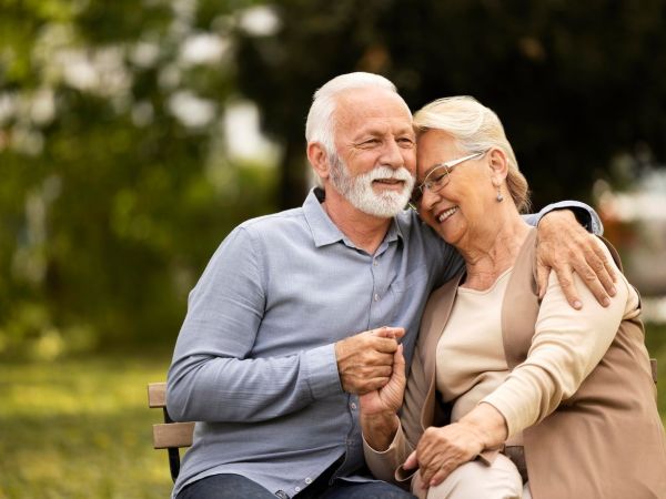 medium shot smiley senior couple sitting